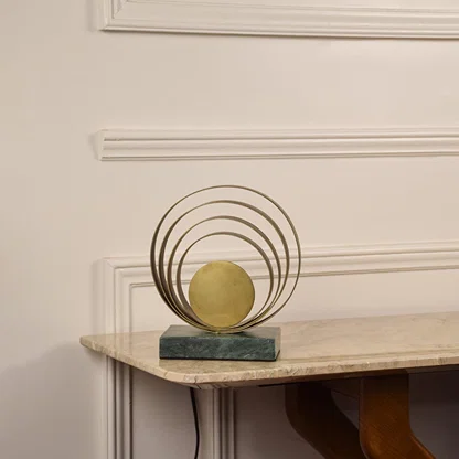 Golden ring lamp unlit on white background featuring layered rings and marble base enhancing modern and minimalist interior aesthetics.