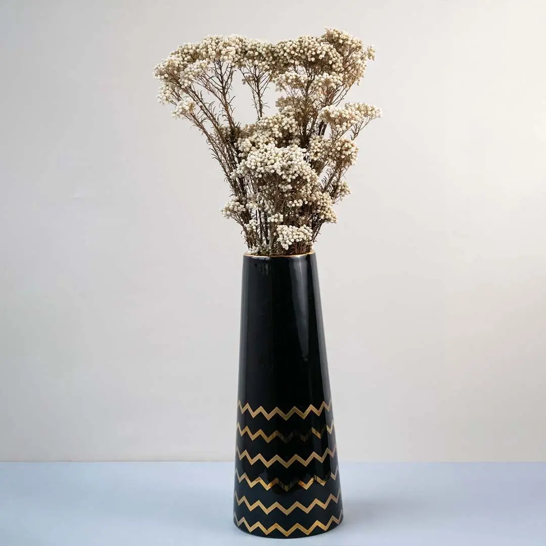 Brown dried gypsophila bouquet preserved flowers styled in tall black ceramic vase lifestyle home decor display.