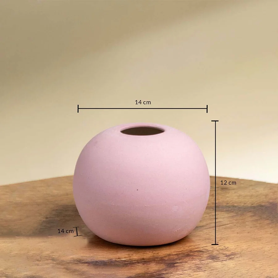 Pink ceramic round vase shown with 14 cm width 12 cm height and 14 cm depth on a wooden surface for accurate product sizing.