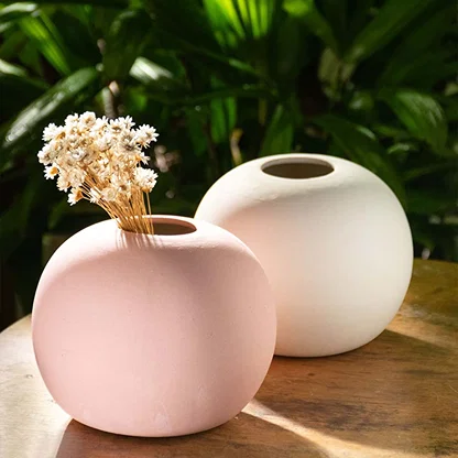 Pink ceramic round vase styled with complementary decor items creating a cohesive modern setup perfect for living room and tabletop styling.