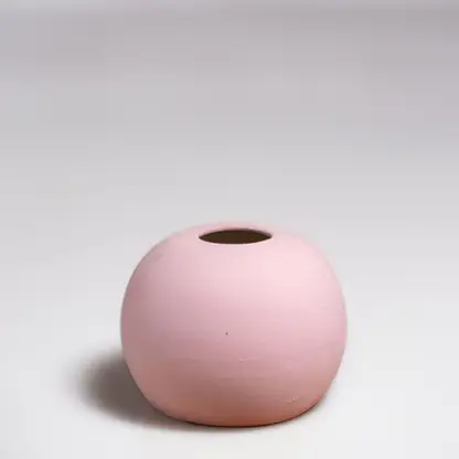 Pink ceramic decorative vase with rounded minimalist silhouette for elegant tabletop styling and modern home decor.