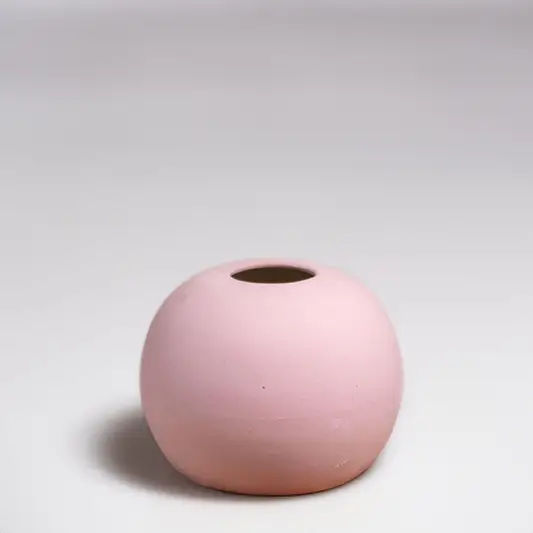 Pink ceramic decorative vase with rounded minimalist silhouette for elegant tabletop styling and modern home decor.