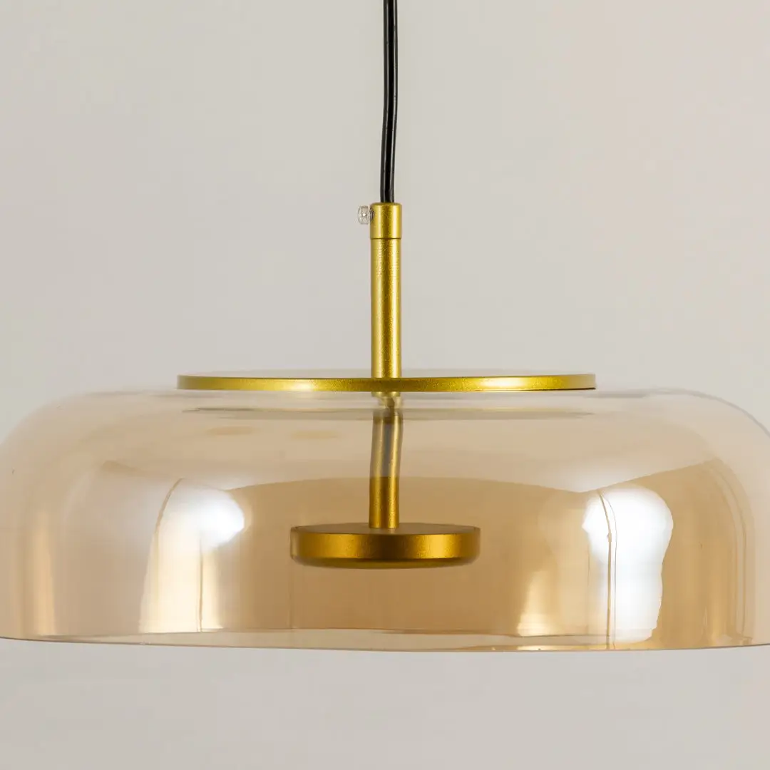 Gold metal pendant light with wide dome shade and sleek design ideal for modern kitchen island or dining decor placement.