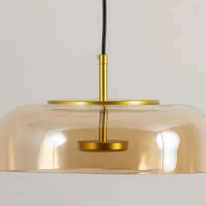 Gold metal pendant light with wide dome shade and sleek design ideal for modern kitchen island or dining decor placement.