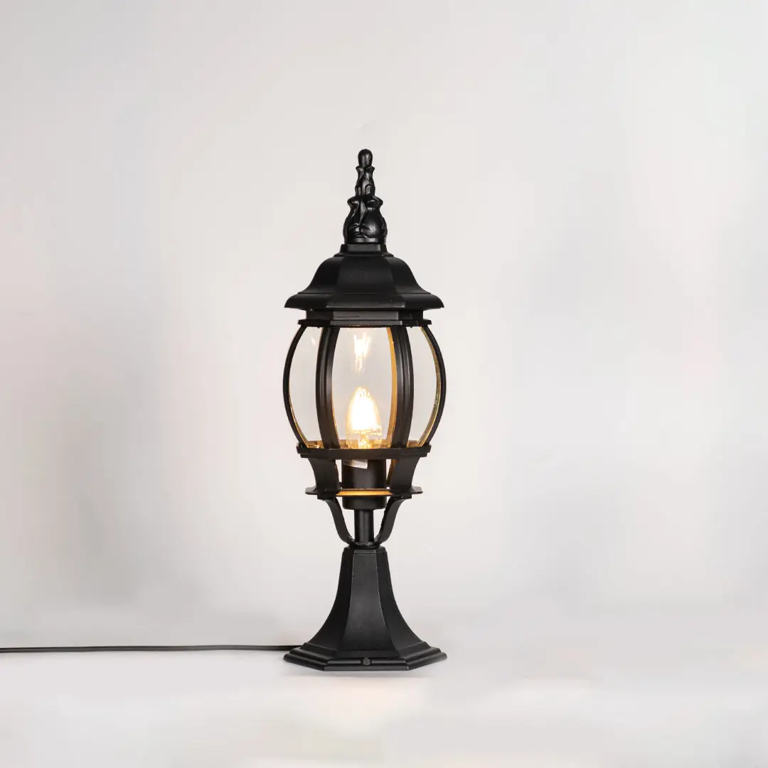 Vintage black outdoor gate light with warm glowing bulb for elegant exterior decor styling use.