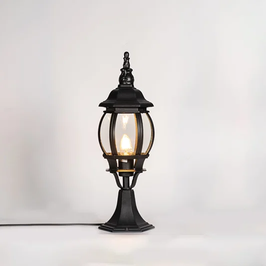 Vintage black outdoor gate light with warm glowing bulb for elegant exterior decor styling use.