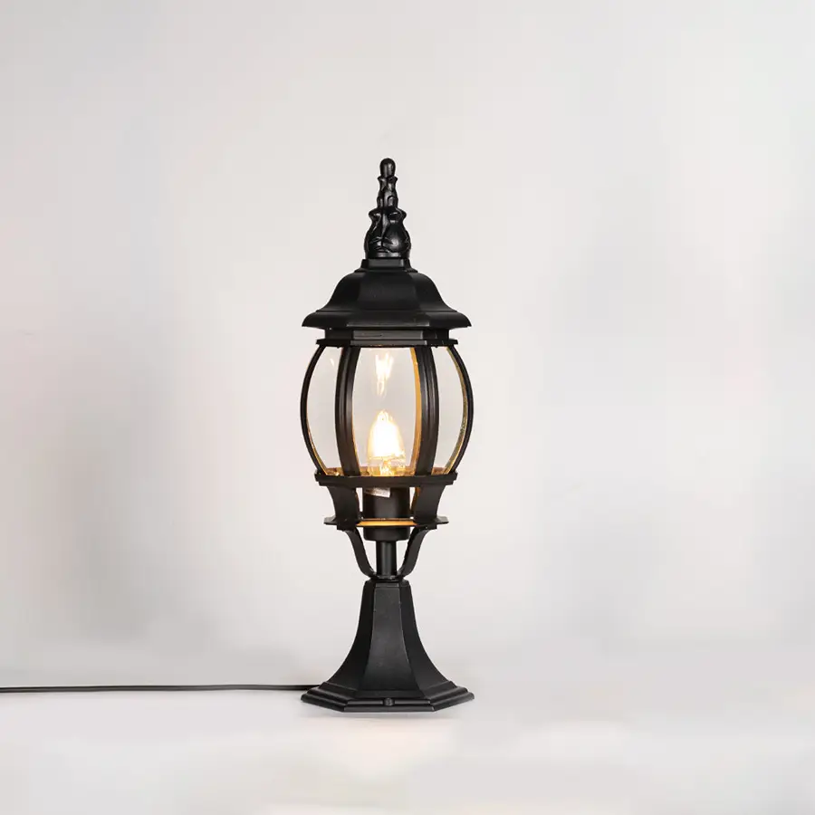 Vintage black outdoor gate light with warm glowing bulb for elegant exterior decor styling use.