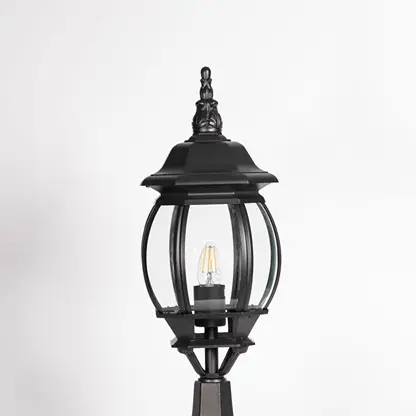 Closeup of decorative outdoor black pillar light with clear curved glass and LED bulb highlighting premium classic design.
