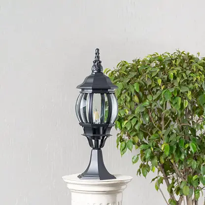 Classic black outdoor pillar lamp with curved glass panels placed on stone pillar ideal for villa entrance and garden decor.