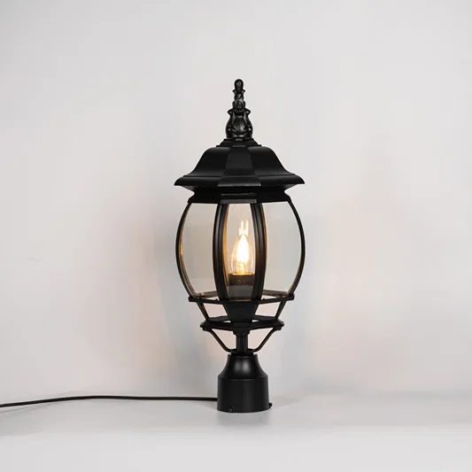 Vintage black outdoor gate light with warm glowing bulb for elegant exterior decor styling use.
