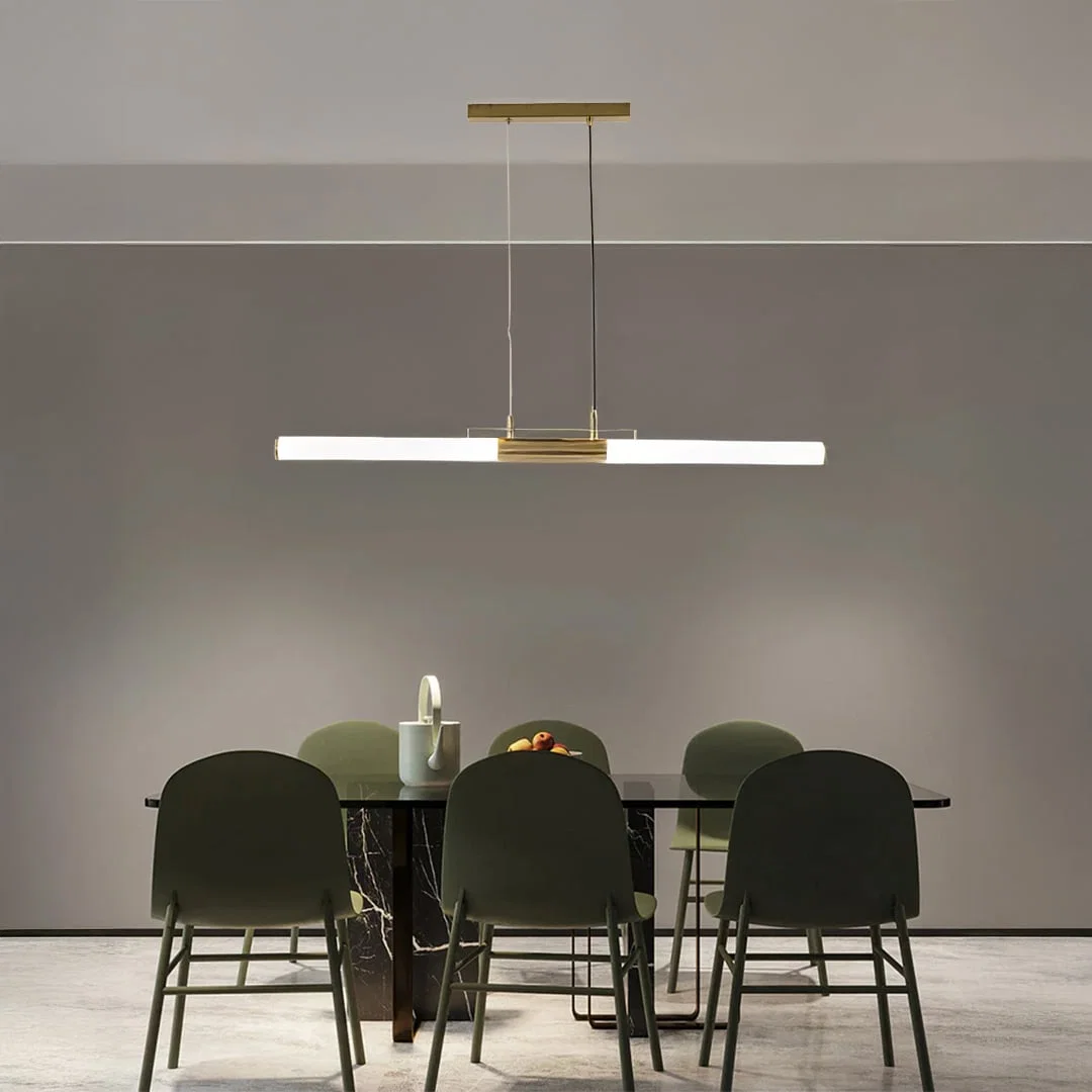 Gold metal linear LED pendant light above dining table creating elegant ambient lighting for modern dining interiors.