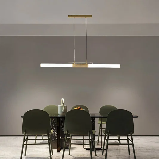 Gold metal linear LED pendant light above dining table creating elegant ambient lighting for modern dining interiors.