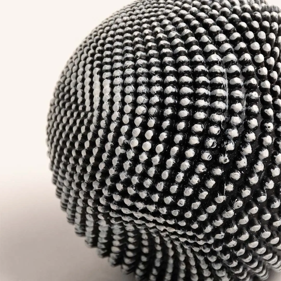 Closeup of black and white textured ball sculpture showcasing intricate pattern and unique design details.