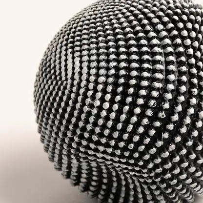 Closeup of black and white textured ball sculpture showcasing intricate pattern and unique design details.