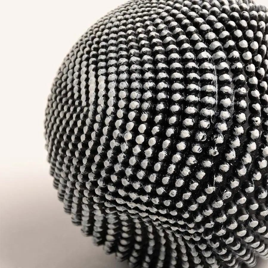 Closeup of black and white textured ball sculpture showcasing intricate pattern and unique design details.