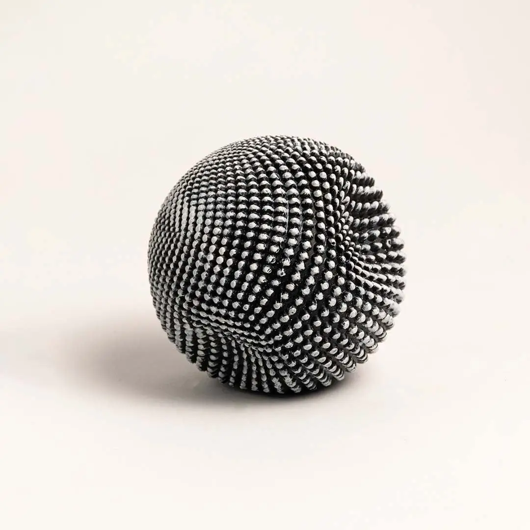 Sculptural black and white ball with intricate texture displayed on a clean white background highlighting its design.
