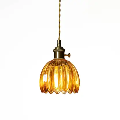 Amber ribbed glass pendant light with antique brass accents creating cozy illumination indoors.