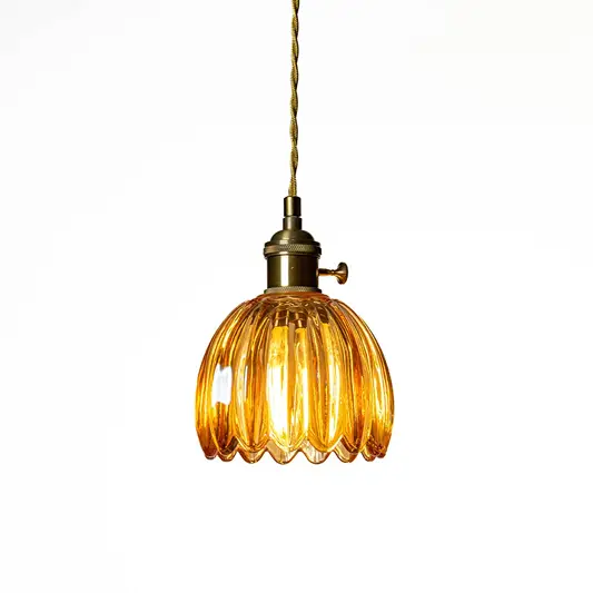Amber ribbed glass pendant light with antique brass accents creating cozy illumination indoors.