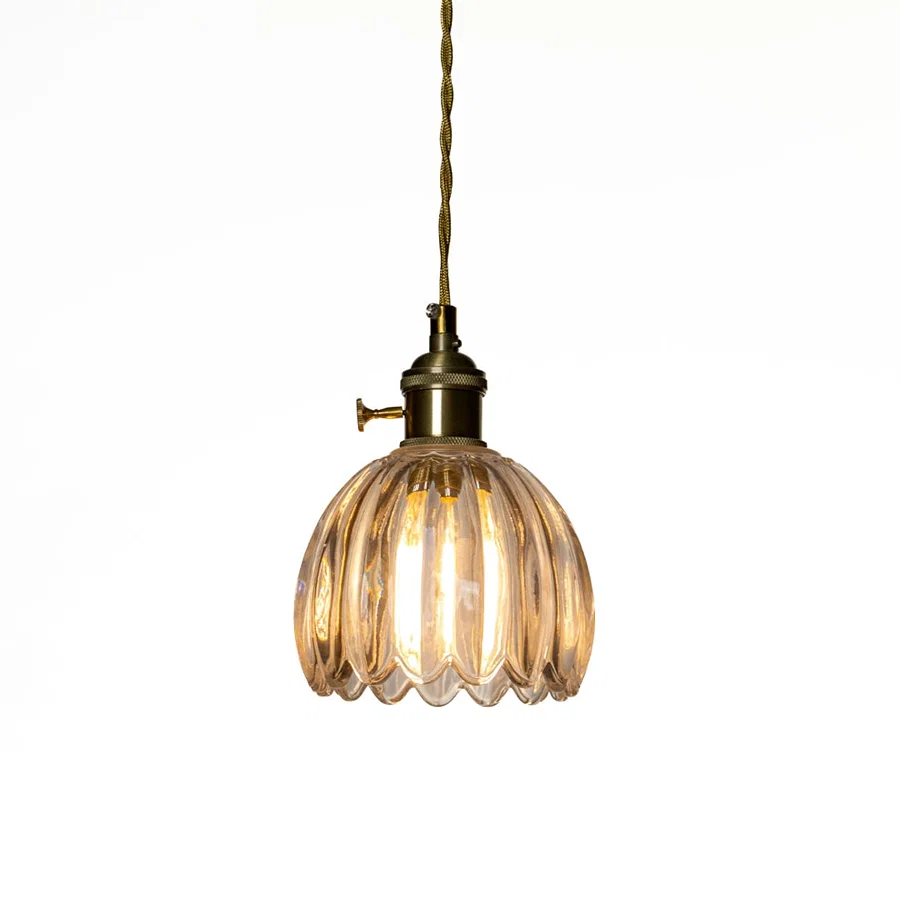 Illuminated amber ribbed glass pendant light casting warm ambient lighting for stylish living spaces.