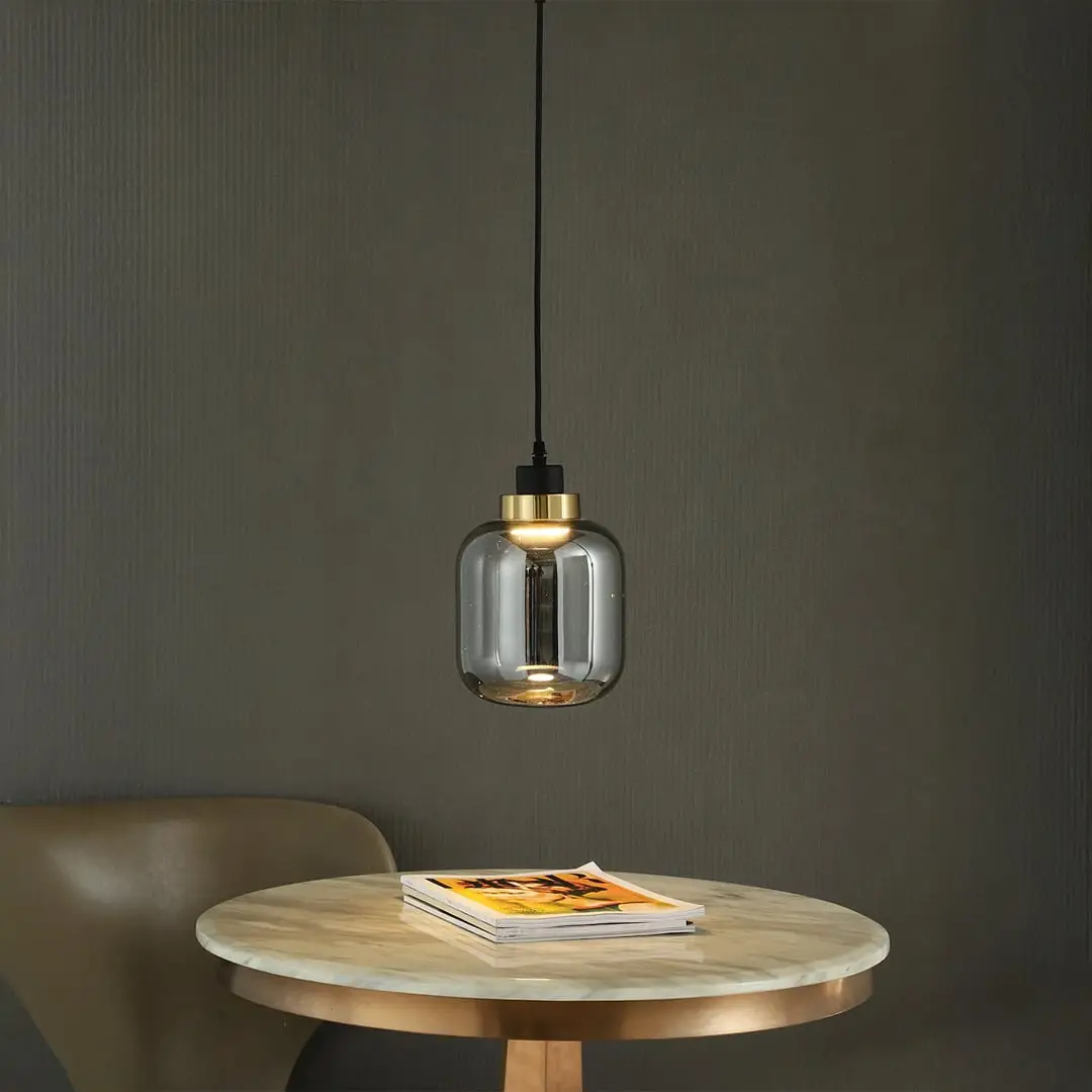 Smoky glass pendant light with warm glow adding sophisticated charm to dining room settings.