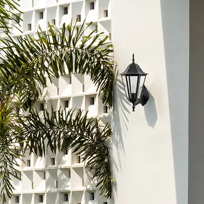 Black metal outdoor lantern wall light lifestyle image on modern exterior wall for stylish patio decor.