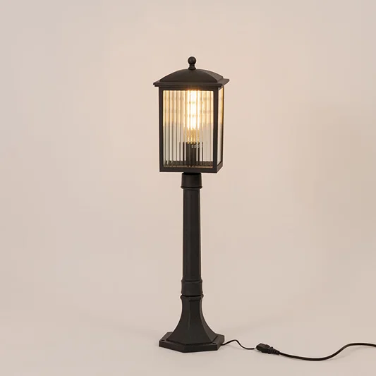 Black outdoor garden light with warm glowing ribbed panels for elegant exterior decor styling use.