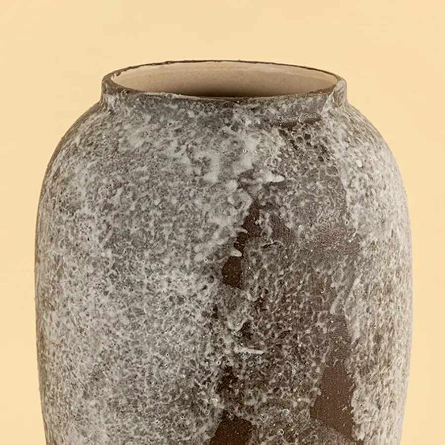 Decorative ceramic vase closeup highlighting natural stone texture speckled glaze and handcrafted finish with earthy tones on a soft neutral background.