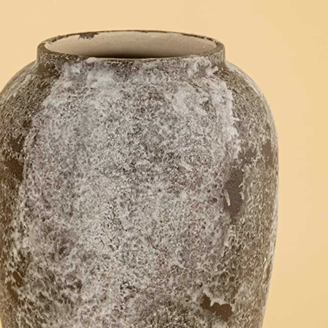 Handcrafted ceramic decor vase closeup showing textured stone finish and organic glazing details photographed on a soft neutral background highlighting surface depth.