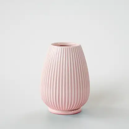 Pink ribbed ceramic decorative vase with rounded silhouette for tabletop styling and modern home decor displays.