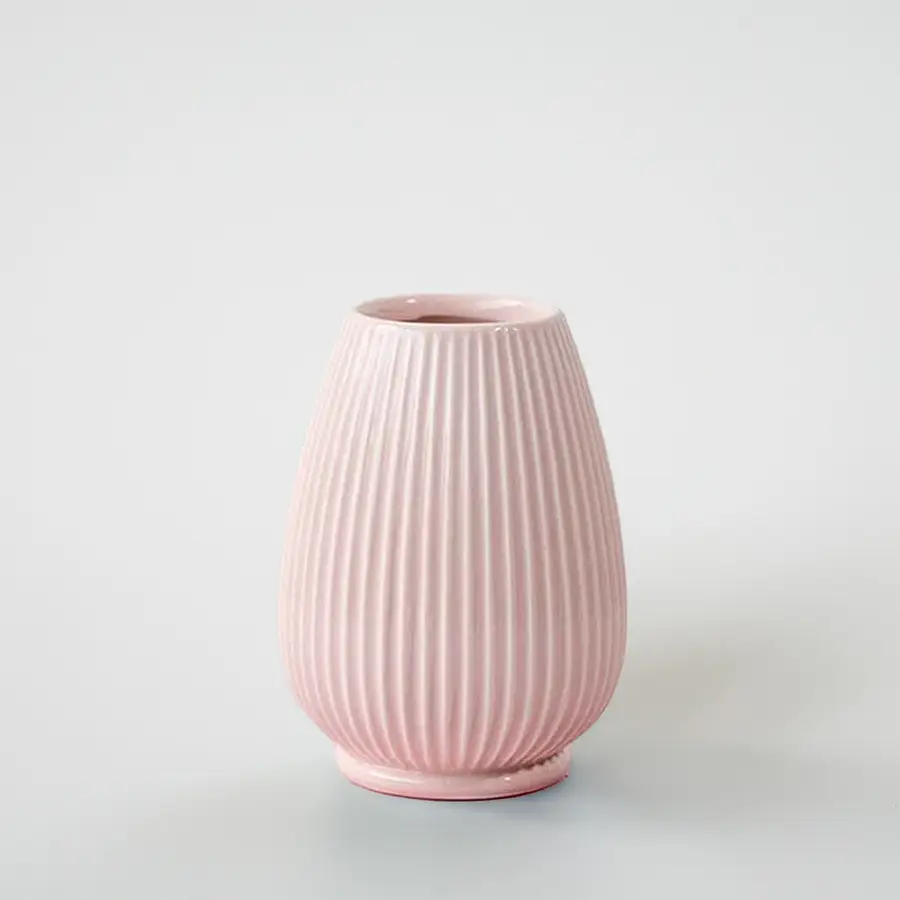 Pink ribbed ceramic decorative vase with rounded silhouette for tabletop styling and modern home decor displays.