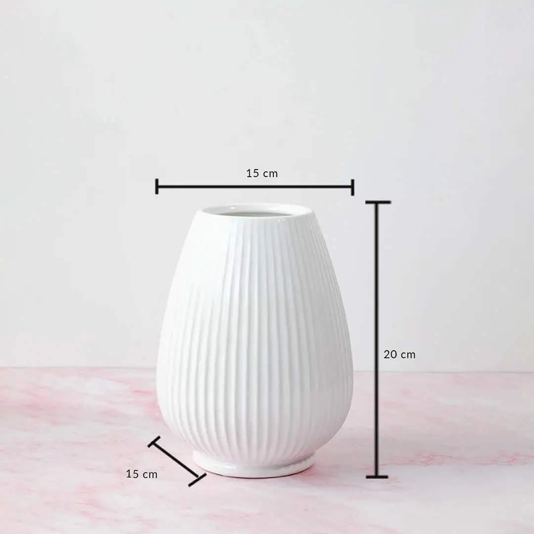 White ribbed vase with product dimensions labeled—20 cm height and 15 cm width—displayed on a pink marble background.