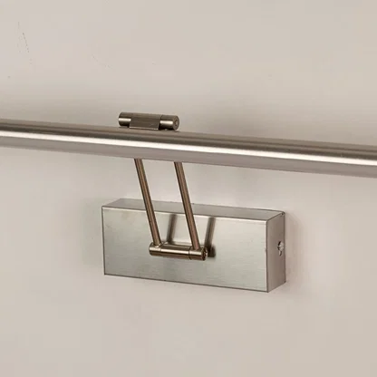 Closeup view of silver picture light highlighting smooth metal body and adjustable arm for focused picture and wall lighting.