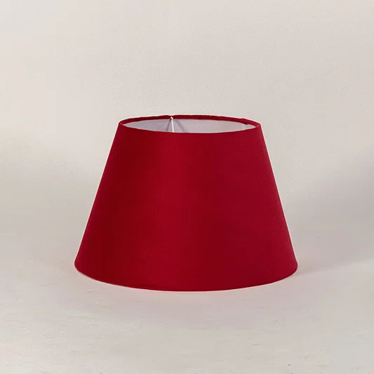 Minimal fabric lampshade in red finish for table or floor lamp soft lighting and home decor placement white background.