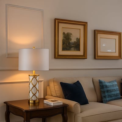 White and gold ceramic table lamp with fabric shade placed on wooden console for elegant living room decor styling.