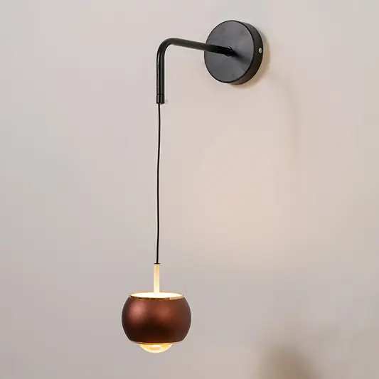 Modern black and brass pendant wall light with warm glow for elegant bedroom interior decor.