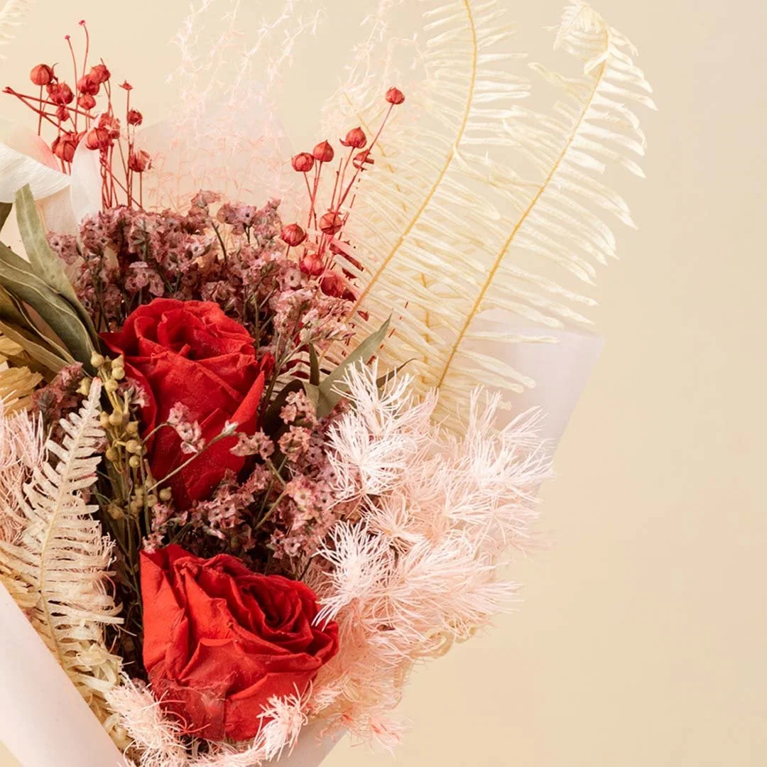 Closeup of Infinity Rose Red bouquet showing dried eucalyptus red infinity rose fern asparagus and crystal grass.