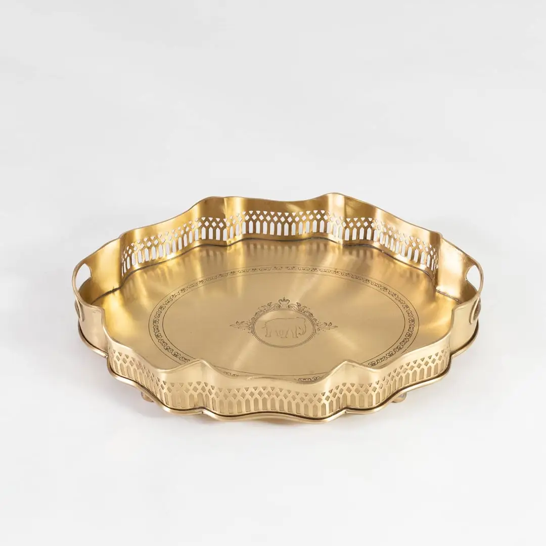 Flat brass tray with decorative rim and side engravings shown in front view against a clean white backdrop.
