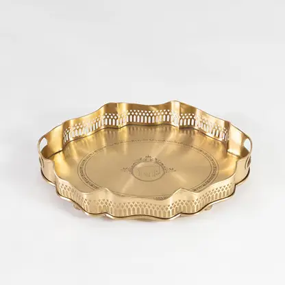 Flat brass tray with decorative rim and side engravings shown in front view against a clean white backdrop.