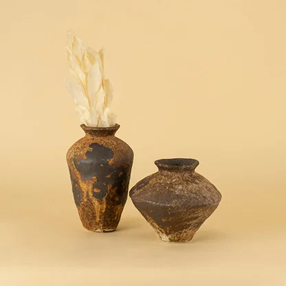 Set of rustic brown ceramic vases in varied shapes styled together creating artistic earthy home decor display
