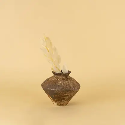 Rustic brown ceramic vase with textured finish styled on wooden table adding earthy elegance to home interior decor
