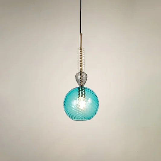 Blue glass pendant light glowing softly on white background showcasing modern design for stylish dining room and living space lighting.