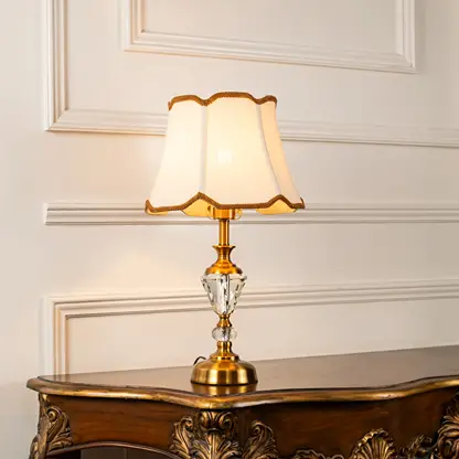 Clear crystal table lamp with scalloped fabric shade offering refined classic ambient lighting for elegant home interiors.