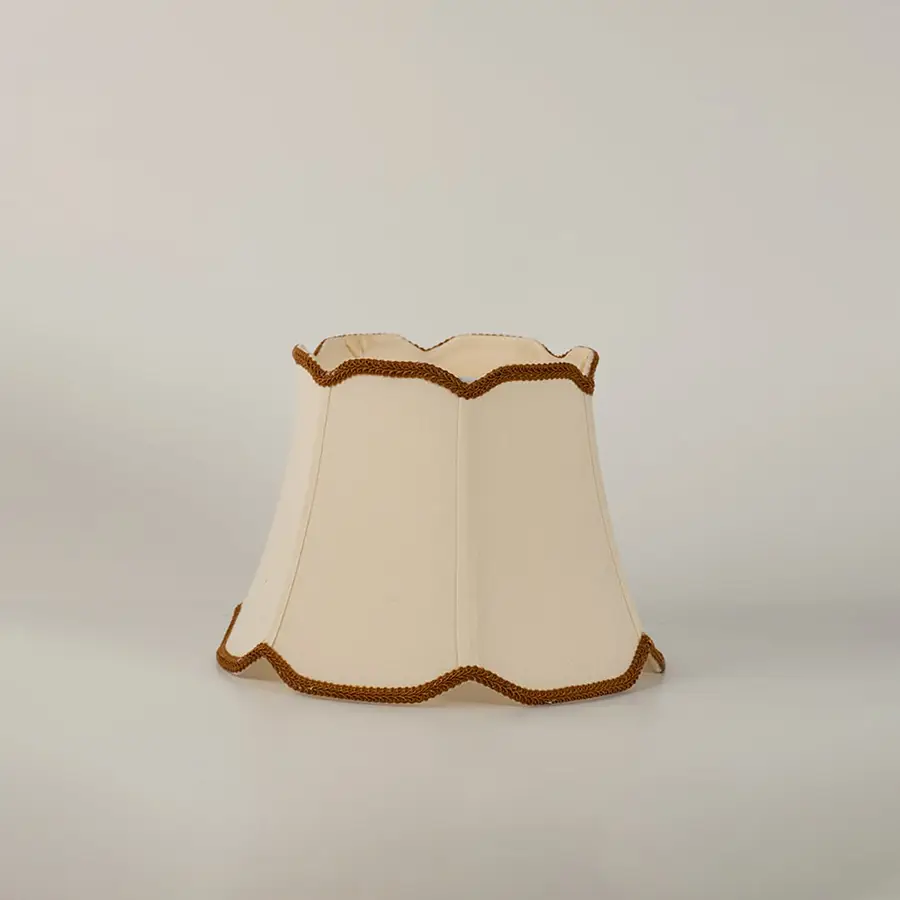 Cream fabric lamp shade with decorative trim shown alone on white background replacement shade for table lamp.
