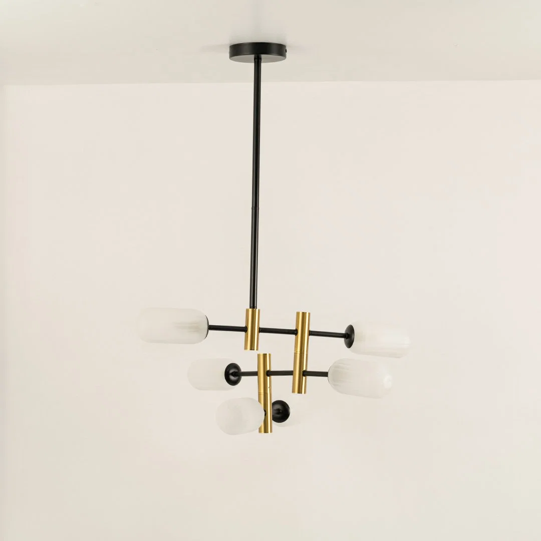 Gold and black metal chandelier with frosted glass tube shades designed for stylish modern ceiling lighting indoors.