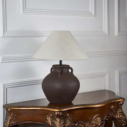 Brown ceramic table lamp with beige linen shade unlit on white background styled for home interior decor table lamp.
