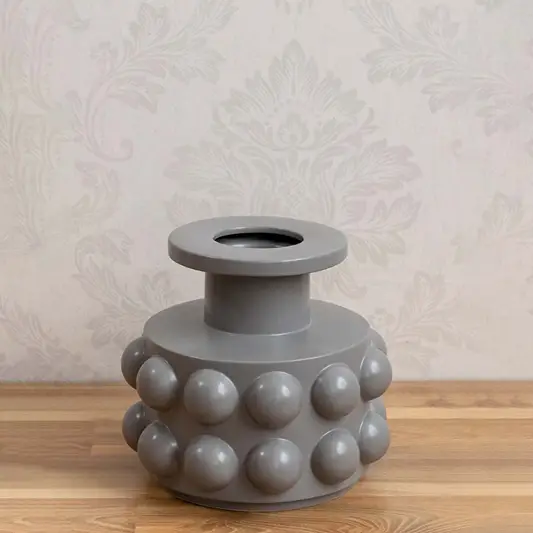 Grey ceramic decorative vase with sculptural bubble design styled on a table for contemporary home decor settings.