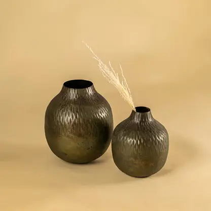 Brown hammered metal vase decor paired with matching pieces creating an earthy modern accent for shelves and living room styling.