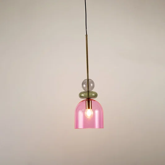 Green and pink glass pendant light illuminated to display stylish hanging light design with soft ambient glow.