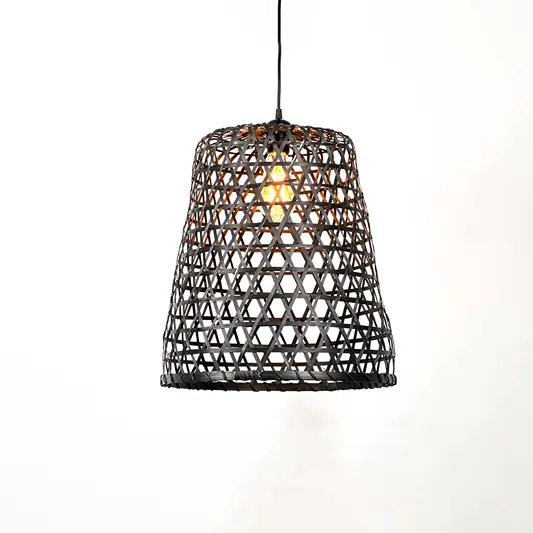 Black metal and cane pendant light with textured open weave pattern and warm bulb glow hanging against soft neutral wall background for contemporary decor.