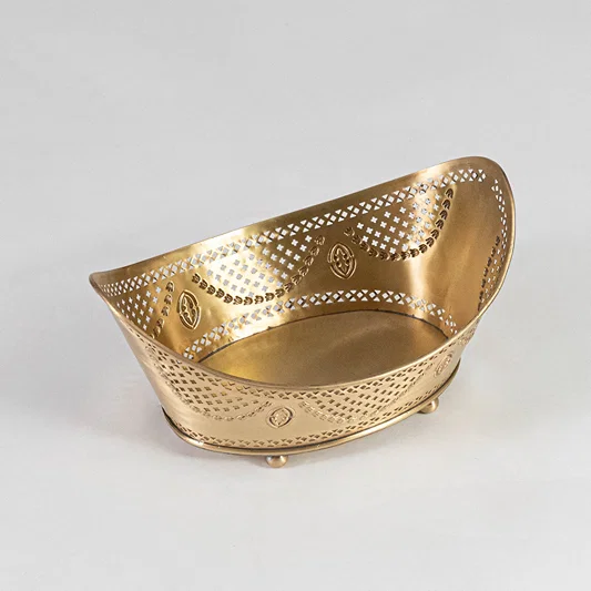 Contemporary metal basket in gold finish with perforated design for dining table or serving decor accessory placement white background.